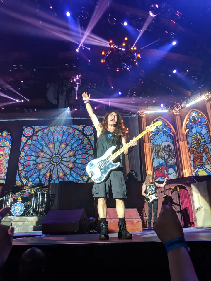 Steve Harris, bras levé, vitraux derrière